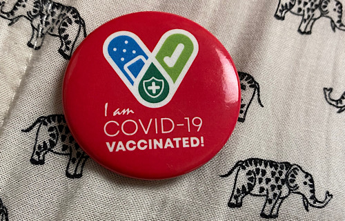 Picture of a pin that says "I am COVID-19 Vaccinated!"